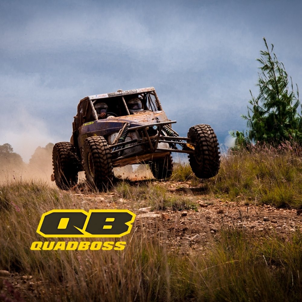 UTV driving over all-terrain trail with QuadBoss logo overlay