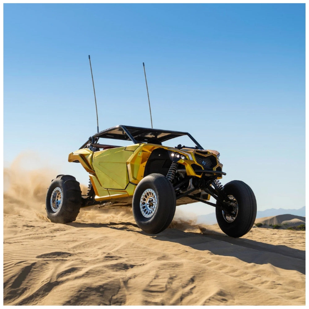 Yellow off-road vehicle driving on sand with a clear blue sky. Tensor sand series tires installed.