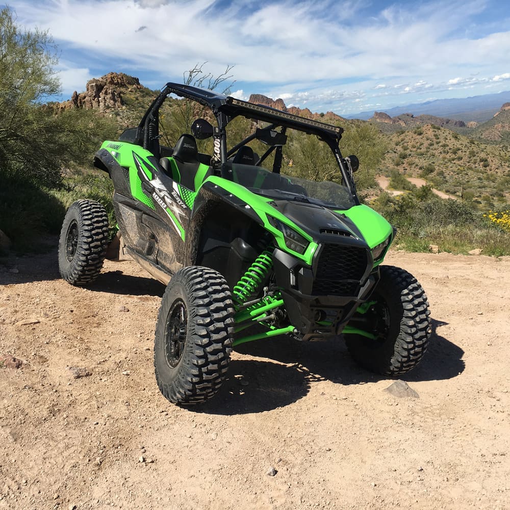 AMS M2 Evil tires mounted on Kawasaki Teryx side-by-side, parked in the western desert on hard pack.