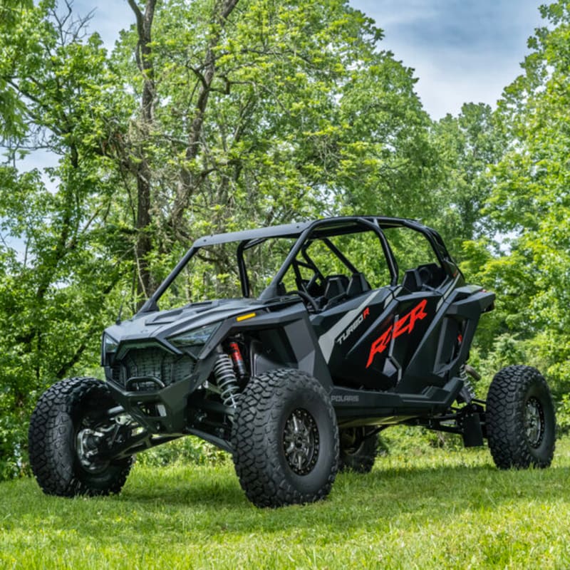 Polaris RAZR TurboR side-by-side with ITP Intersect radial tires installed, parked on grass near trees.