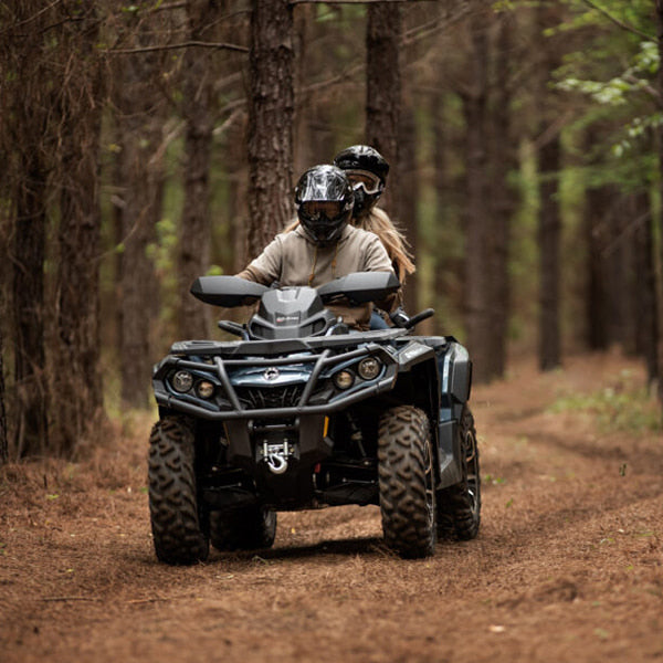 Riders driving a quad through the forest with high traction radial 6-ply durable Terra Cross ITP tires installed.
