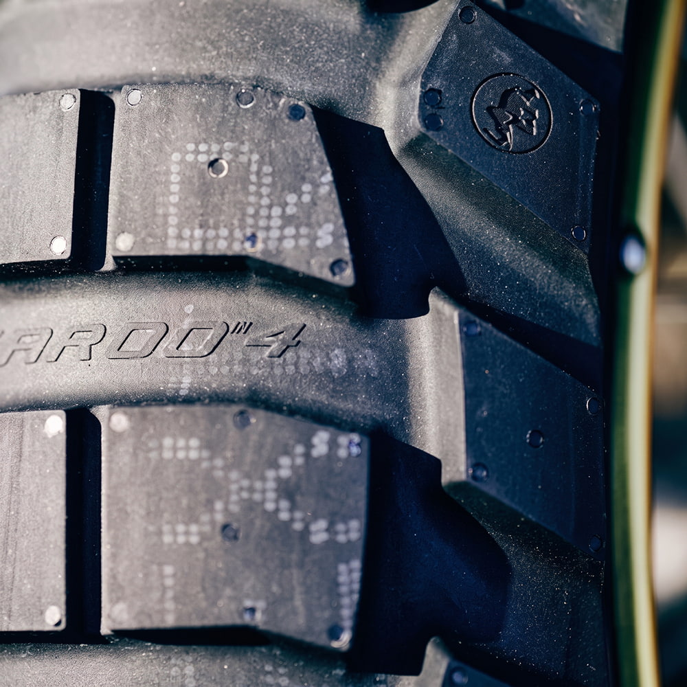 Super close up detailed view of the high performance Metzeler Karoo 4 ADV and Dual-Sport motorcycle tire, featuring patented lug design technology, and featuring model name and branding molded into the tire casing and shoulder tread blocks.