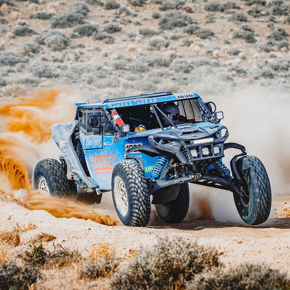 Action photo of the SunF racing team on a desert course with a Can Am Maverick R mounted with the all new SunF Trail Titan 35x10-15 10-ply high performance all-terrain tires.
