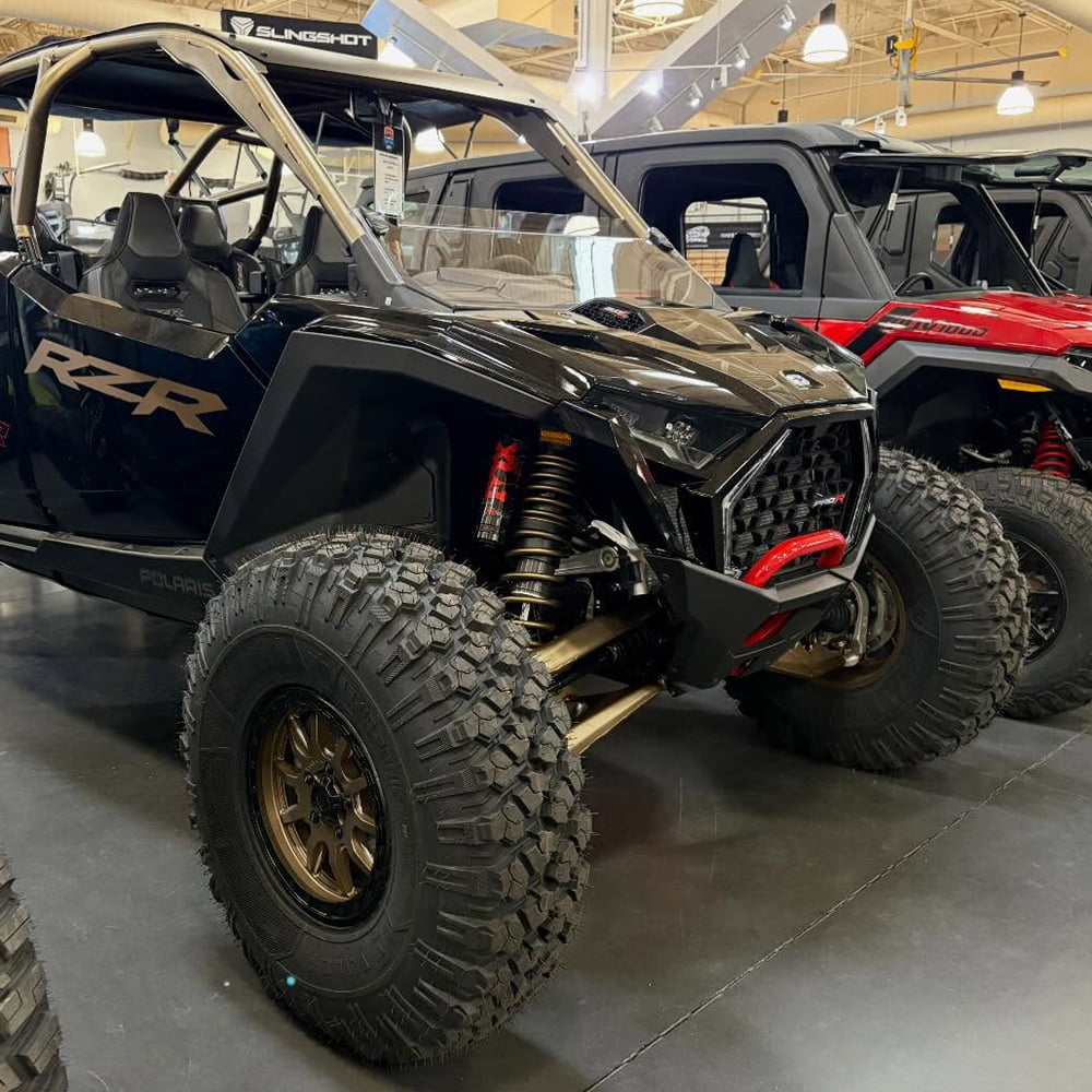 Black and Gold Polaris RZR 1000 UTV parked in a shop with a new pair of Valor Off Road wheels and Alpha tires.