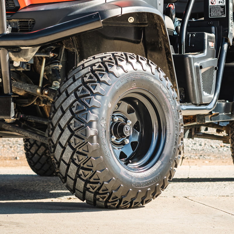 OTR 350 Super Mag tires installed on steel rims and mounted on Kubota RTV, parked on concrete.