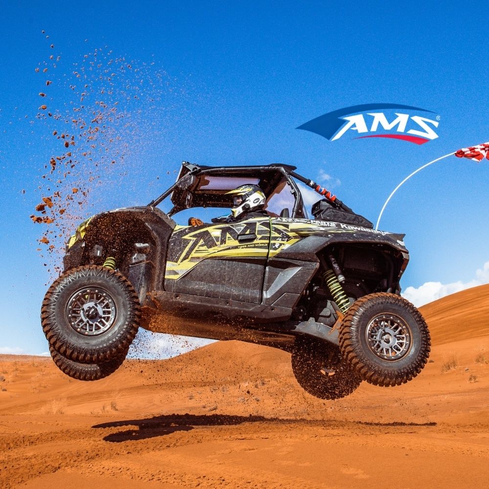 UTV driving on desert terraing with AMS logo and AMS tires. AMS logo imposed on image.