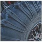 Close-up of the EFX MotoRavage XL with deep tread blocks and a dark multi-spoke wheel, photographed outdoors with shallow depth of field.