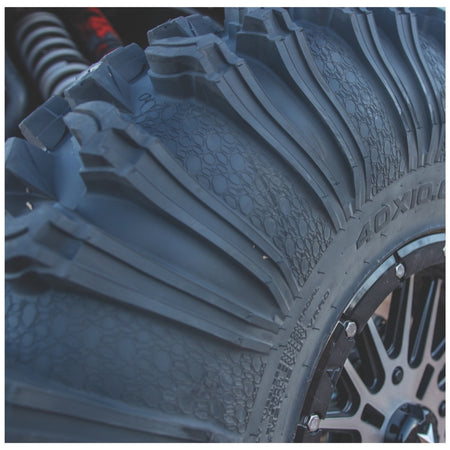 Close-up of the EFX MotoRavage XL with deep tread blocks and a dark multi-spoke wheel, photographed outdoors with shallow depth of field.