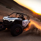 EFX SandSlinger installed on a UTV driving on sandy terrain at sunset