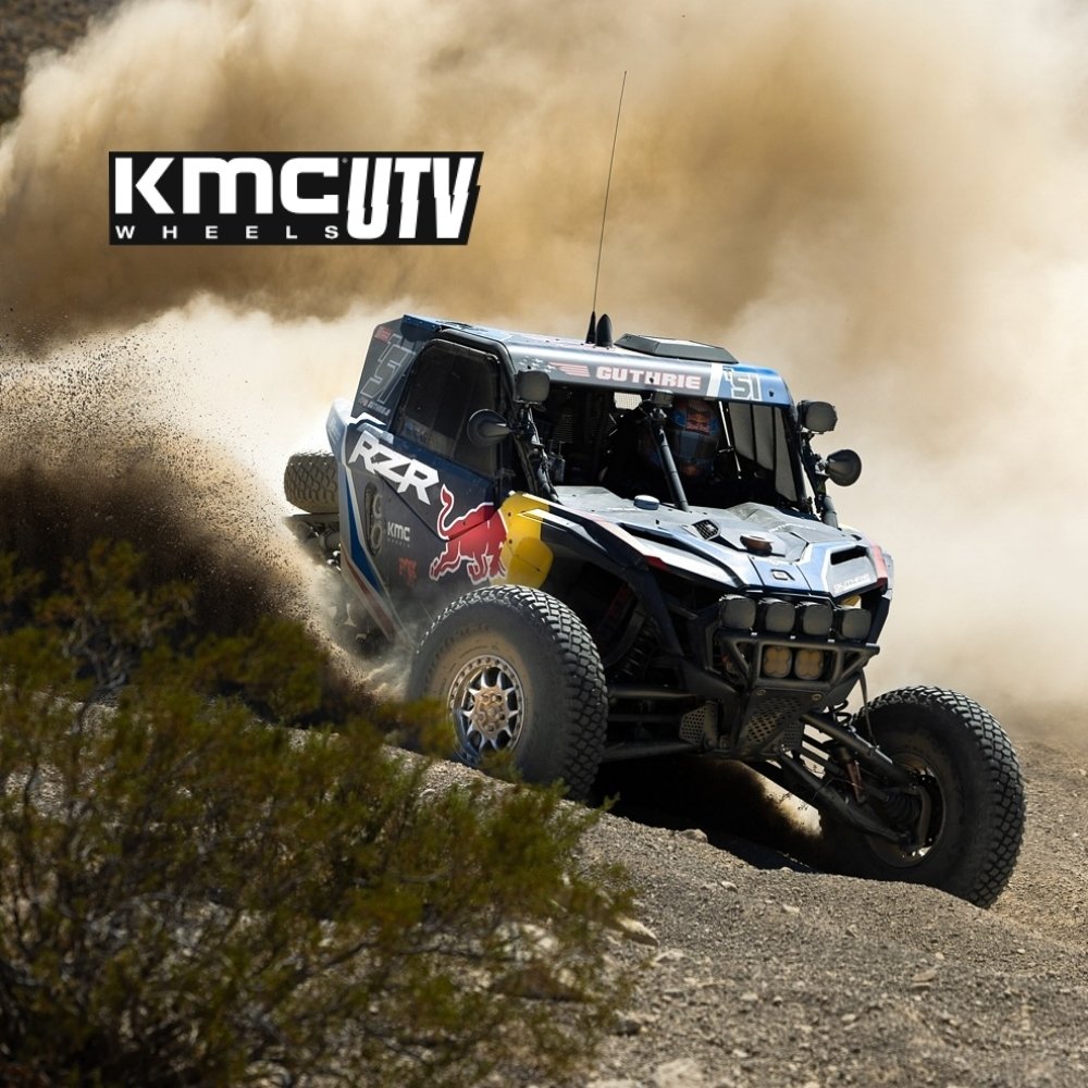 Off-road vehicle racing on a dirt track with KMC UTV tires. KMC UTV logo imprinted on photo.