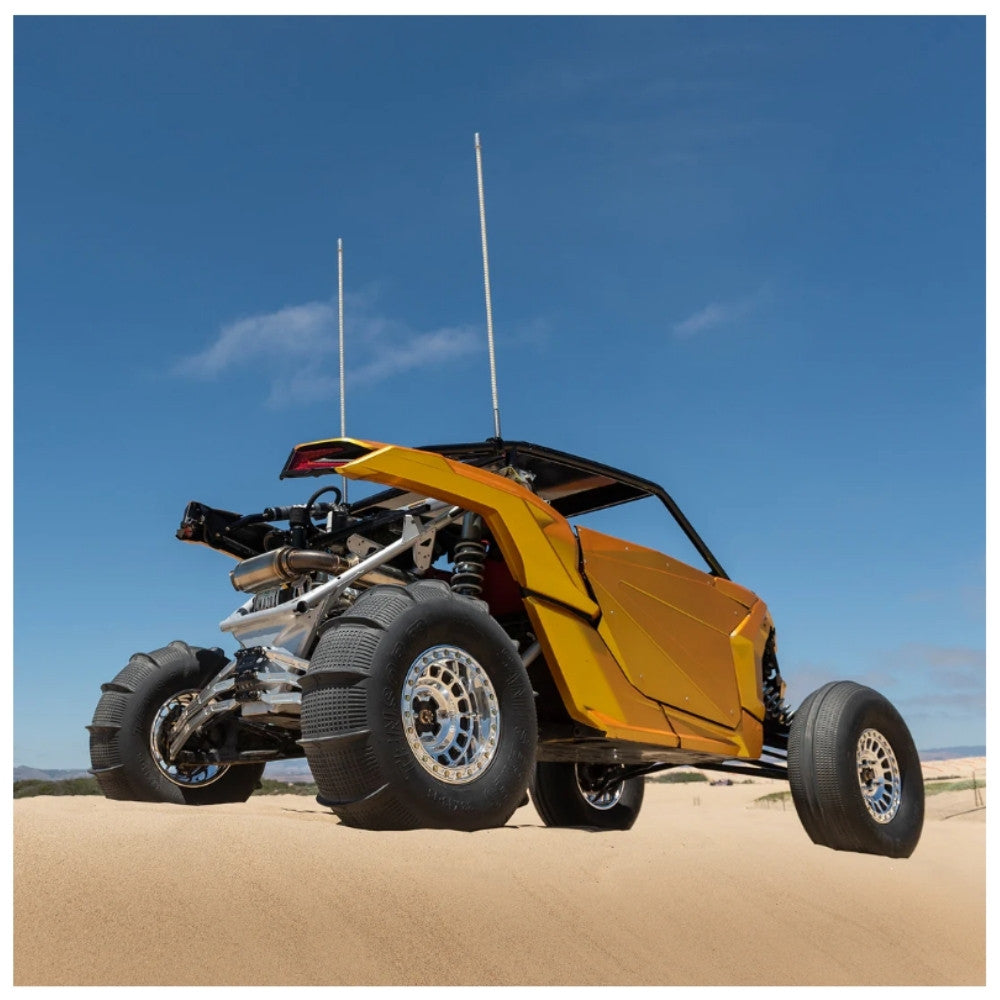 Yellow off-road vehicle on sand with clear blue sky. Tensor sand series tires installed