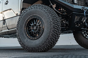 Close-up of the Valor Tange UTV mounted on a black rim with a detailed tread pattern on a vehicle.