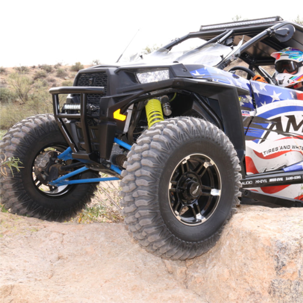AMS M1 Evil all-terrain UTV radial tires mounted on sxs, driving across rocks, demonstrating the great rock crawling tire ability as well as the rugged construction of the 8-ply radial clamshell construction.