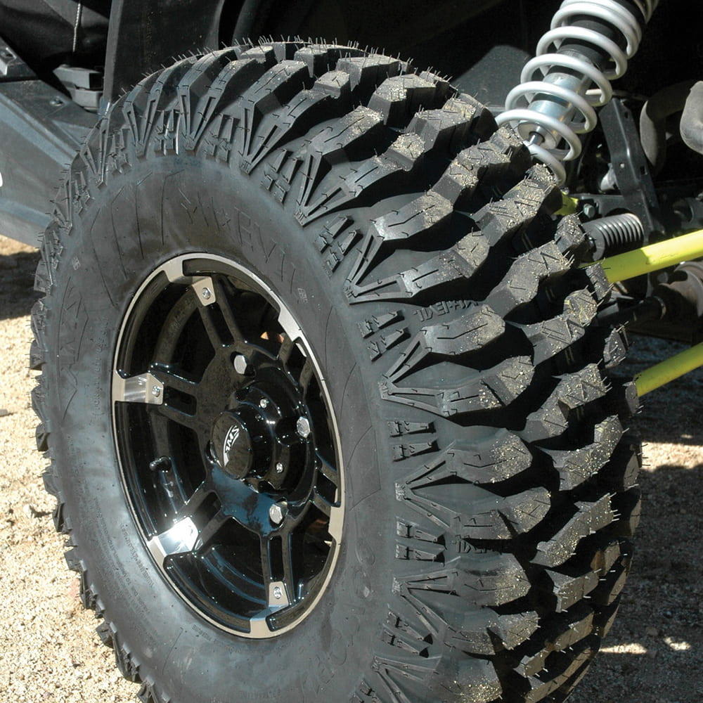 Detailed view of the tread pattern and lug design, as well as the shoulder tread block wrap around lug construction of the AMS M1 Evil UTV tire, designed for premium performance and dependability, with long wearing natural rubber compound, available in overall height sizes up to 34".