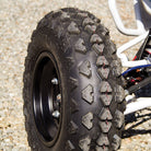 AMS Pactrax front tire installed and mounted on a rim, parked on gravel.