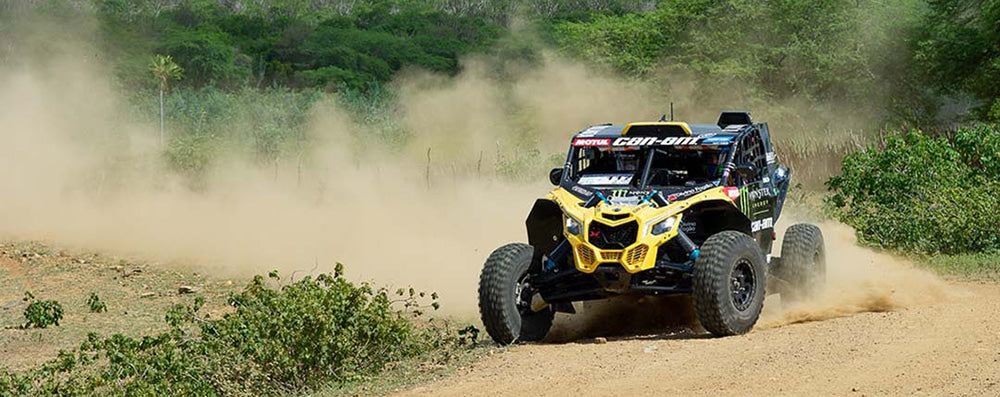 Pro class UTV race SXS wearing Arisun Aftershock XD AR33 high performance 8-ply radial tire with Aramid/Kevlar reinforced sidewalls drifting through a race course corner.