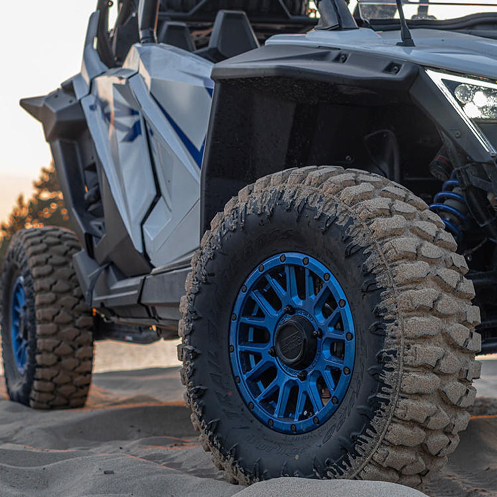 Atturo Trail Blade BOSS SXS tires mounted on Polaris RZR, parked in the sand at the dunes.