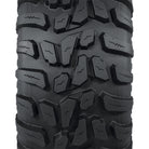 Close up view of the tread pattern and lug design with connecting centerline base block for extended wear and control, featuring block siping for added wet traction, and a high traction all terrain design, great for worksites, hard surfaces, and gravel.