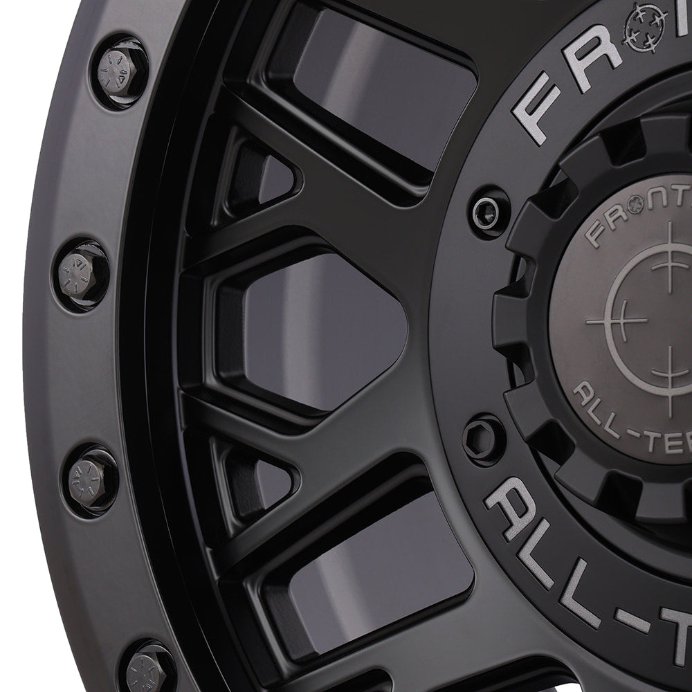 Close up detailed view of the high quality fit and finish on the Frontline 454 beadlock matte black utv and sxs wheel, featuring matte black beadlock rings bolts and screw-on center cap.