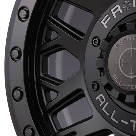Close up detailed view of the high quality fit and finish on the Frontline 454 beadlock matte black utv and sxs wheel, featuring matte black beadlock rings bolts and screw-on center cap.