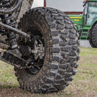 The ITP CrossTrax 8-ply Kevlar reinforced farm and ranch tire mounted on a UTV with a John Deere tractor in the background.