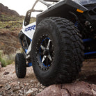 ITP Tenacity tires mounted on ITP rims and installed on a RZR climbing rocky terrain in the mountains.