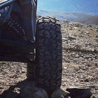 Side by side with Ultra Cross tires by ITP mounted parked in mountains on rocks.