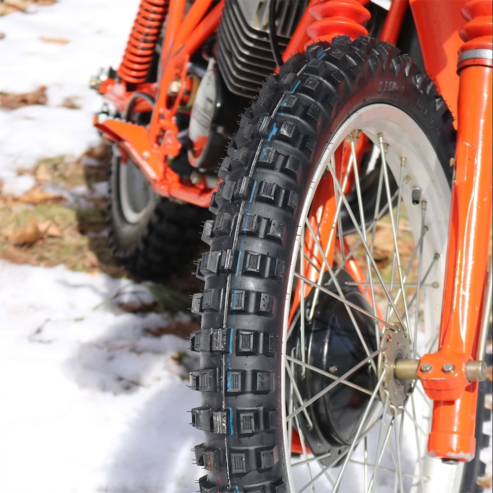 Kenda K257D Klassic front tire mounted on vintage bright orange motorcycle, parked in the snow.