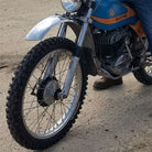 Kenda K257D Klassic motorcycle / dirt bike tire mounted on old restored Bultaco bike, parked on a gravel road.