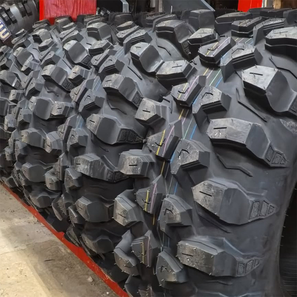 A row of brand new high performance rock crawling, mud terrain Kenda Warhawk K3214 Side-by-side UTV tires, ready to be purchased and put to the test.