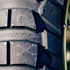 Super close up detailed view of the high performance Metzeler Karoo 4 ADV and Dual-Sport motorcycle tire, featuring patented lug design technology, and featuring model name and branding molded into the tire casing and shoulder tread blocks.