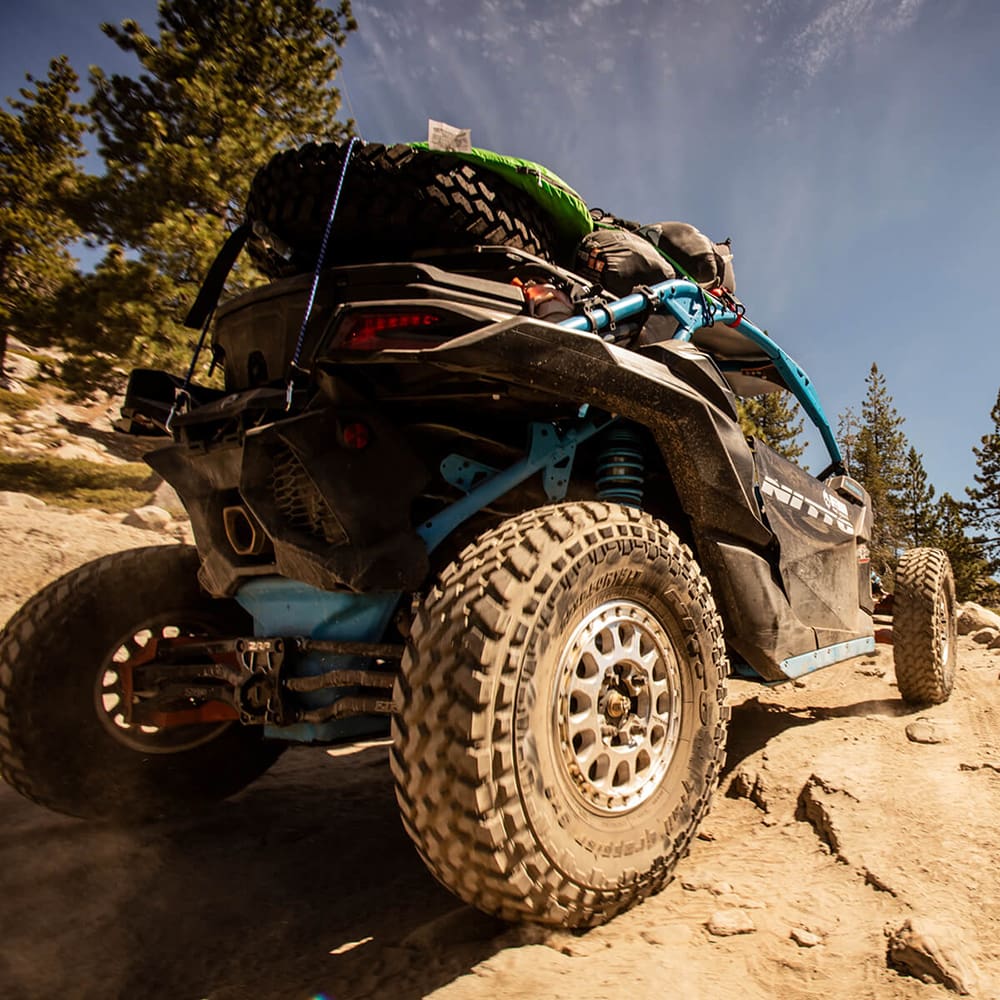 Side-by-side parked on mountain trail, equipped with Nitto Trail Grappler tires mounted on 15" beadlock rims.