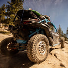 Side-by-side parked on mountain trail, equipped with Nitto Trail Grappler tires mounted on 15" beadlock rims.