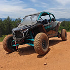 SunF A066 Trail Titan tires installed and mounted on a Polaris RZR Pro R parked on a trail in the mountains.
