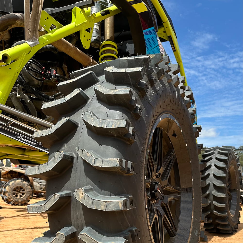 Close up view of the extra wide System 3 XT400W mud and swamp tire, showcasing the extra deep 2" lugs, mounted on System 3rims and installed on a custom built mud bogger.