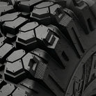Close up detailed view of the tread block pattern and shoulder lug design of the Valor Alpha tire, showcasing the staggered and stepped lug design with tread void texture to promote mud and debris cleanout.